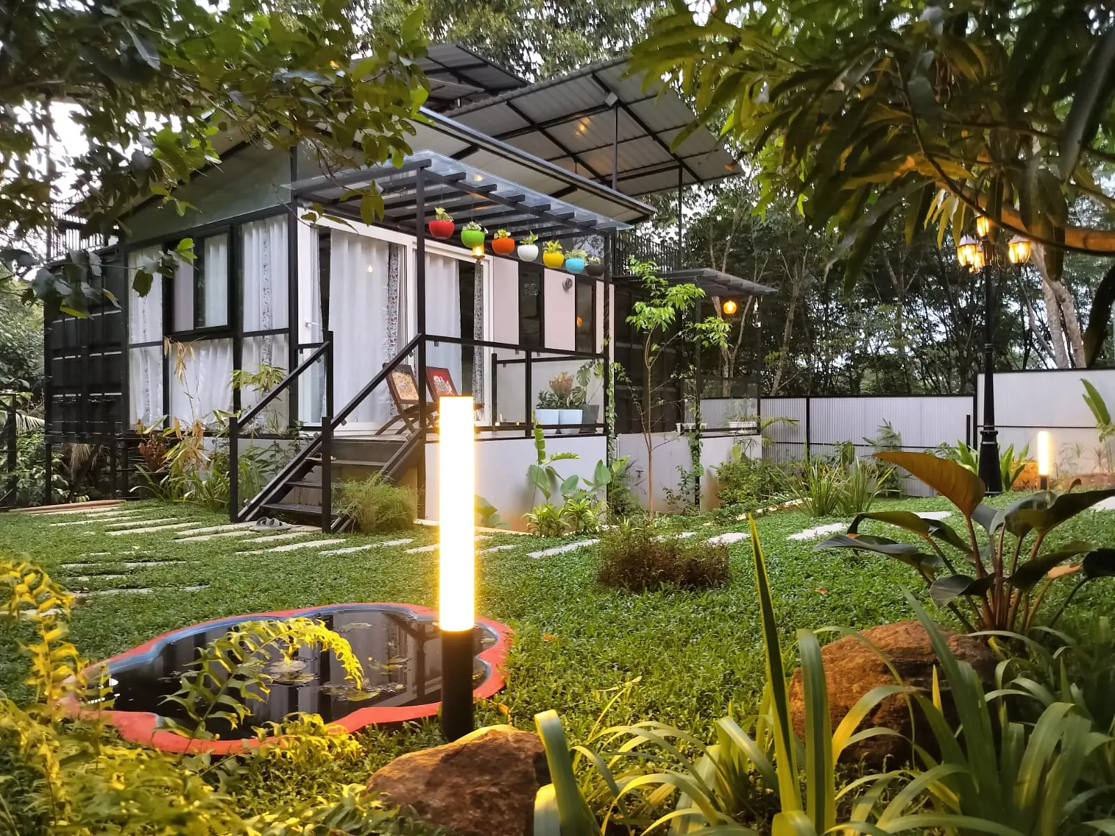 Container Home Vibes surrounded by its garden in the evening